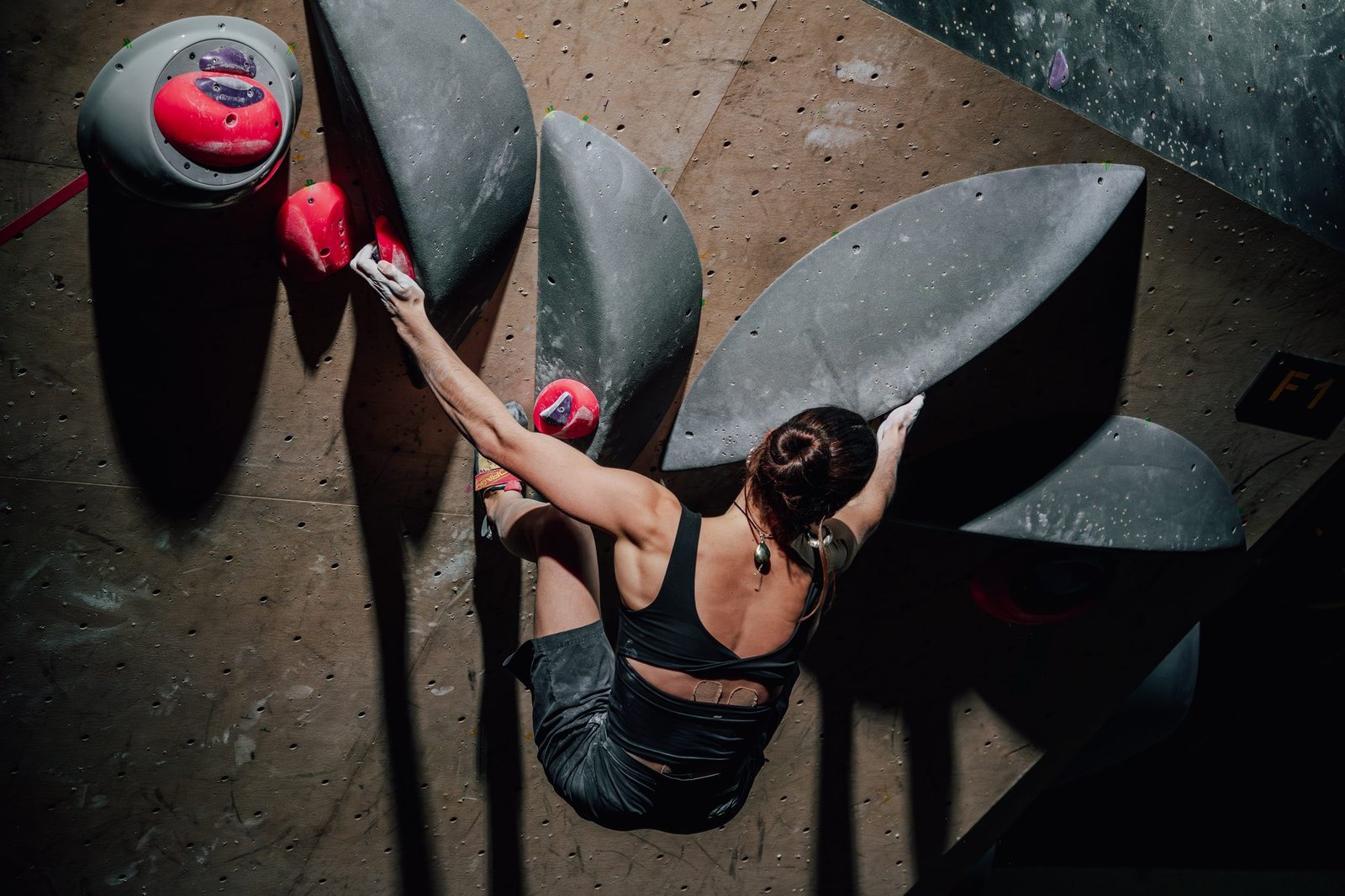 Grimpeuse en pleine ascension sur un mur de bloc